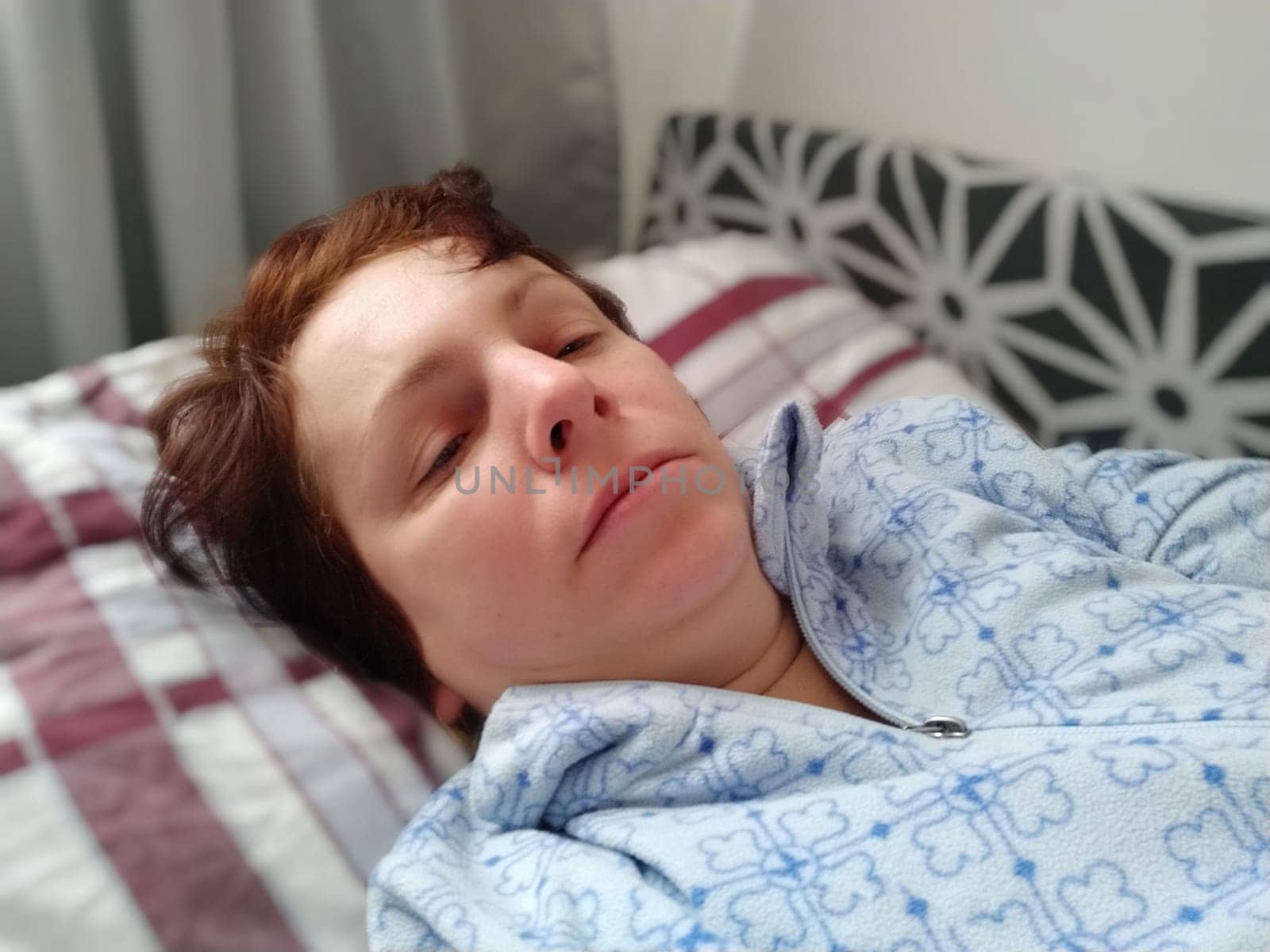 Sick woman in bed. Headache, runny nose and cold. Paleness of the face and faintness of the body. Feeling unwell. The patient lies on a pillow. Loss of consciousness or shock