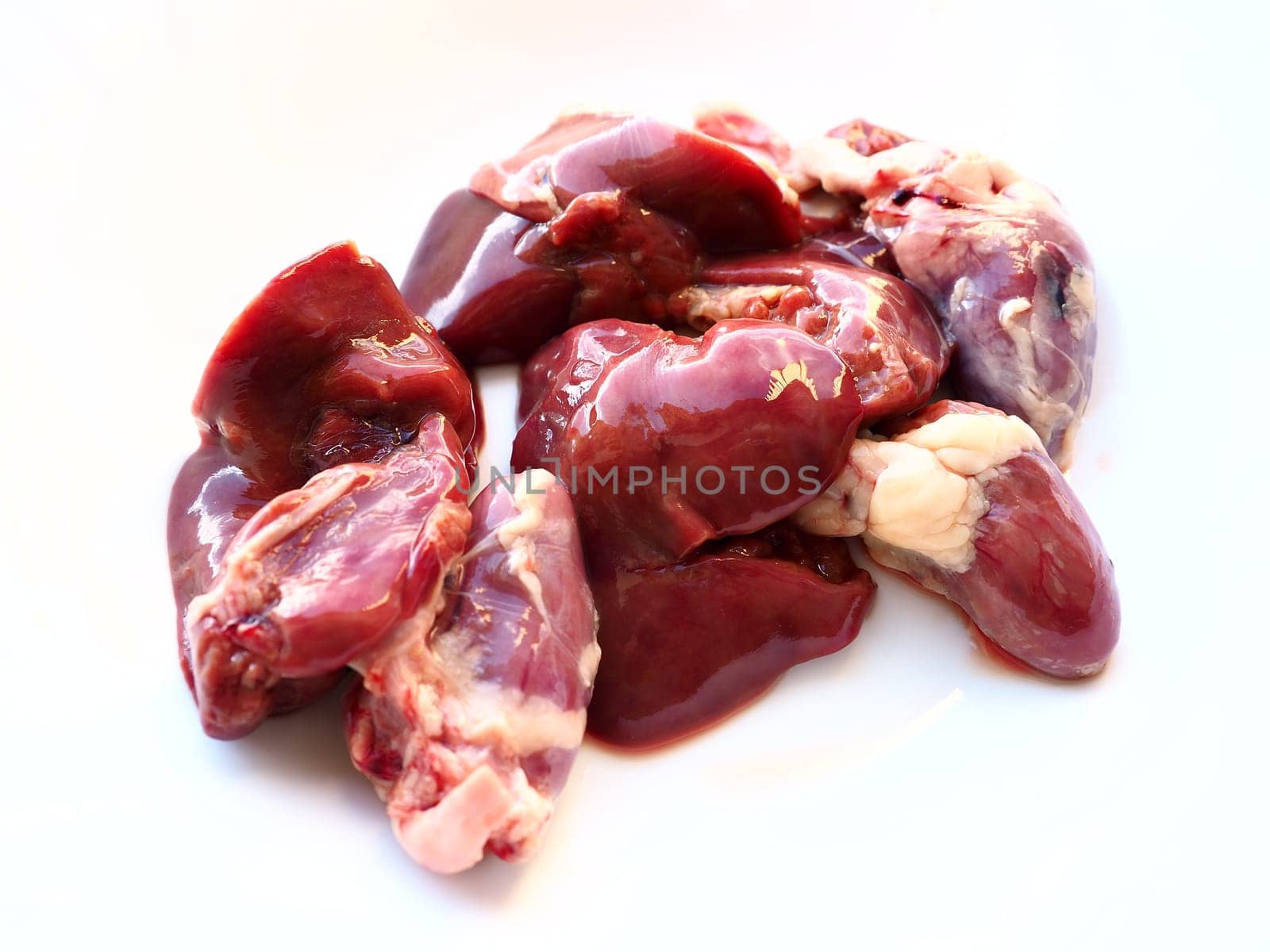 raw chicken liver, kidneys and heart. Poultry entrails and offal, prepared for cooking. A diet high in heme iron against anemia. Meat on white background.