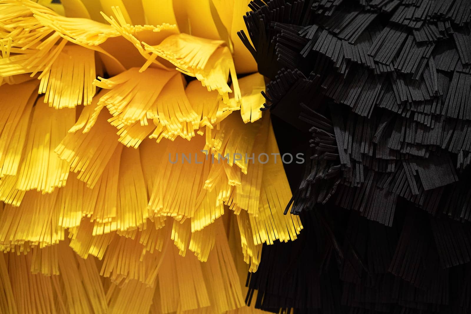 front view closeup detail of black and yellow automatic car wash system cleaning fiber sponge brushes on spinning rotor