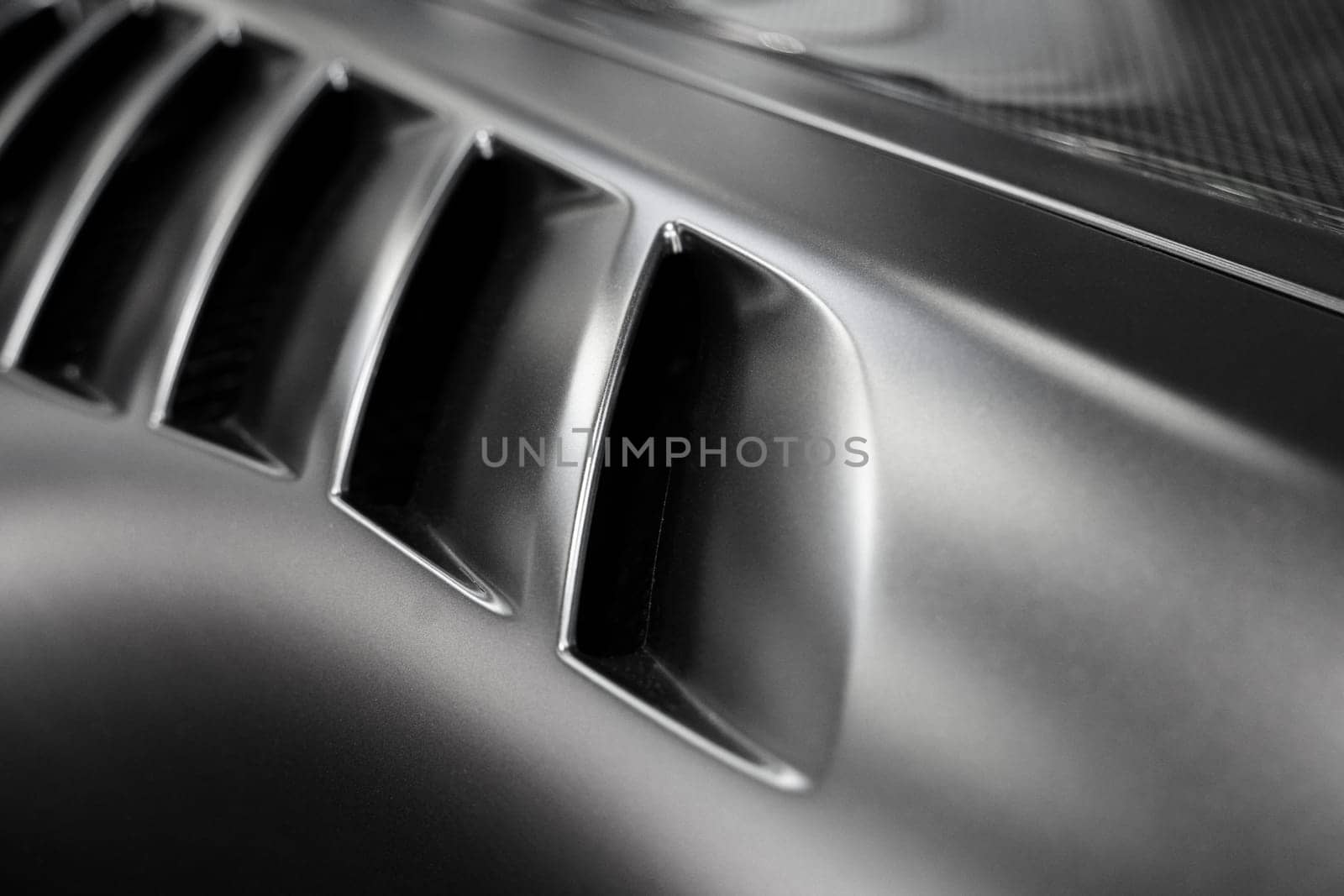 front view closeup detail of black sport car with dark metal hood and air flow intake ornament