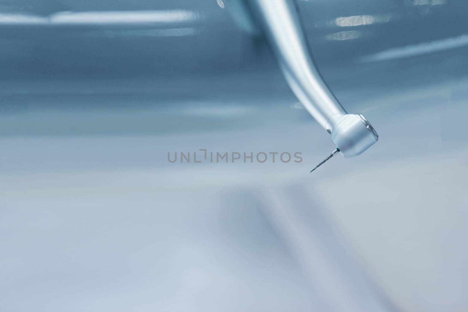 extreme closeup of dental stainless steel drill bit dentist instrument on blue blurry background with copyspace