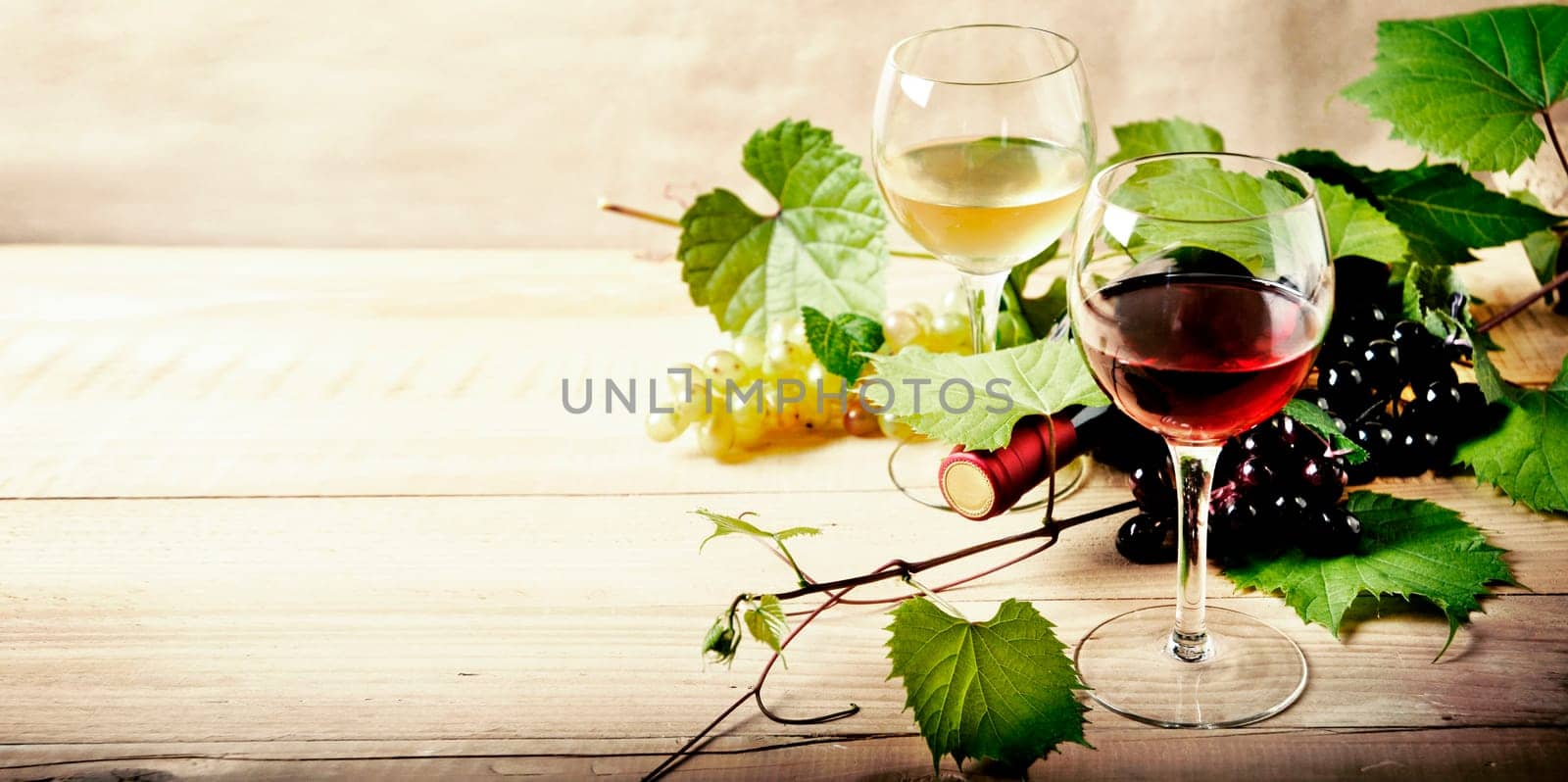 Glass of red and white wine, bottle and grape vine on vintage wooden table. Winery and wine tasting concept. Restaurant vine list design banner background.