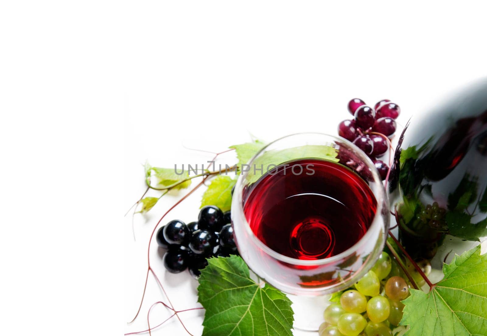 Top view of glass of red wine and bottle with grape vine isolated over white background. Wine tasting border design banner. Wine art shop and winery concept.