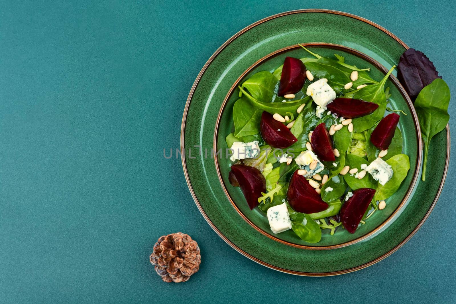 Salad with boiled beetroot, blue cheese, herbs and pine nuts. Food recipe background.