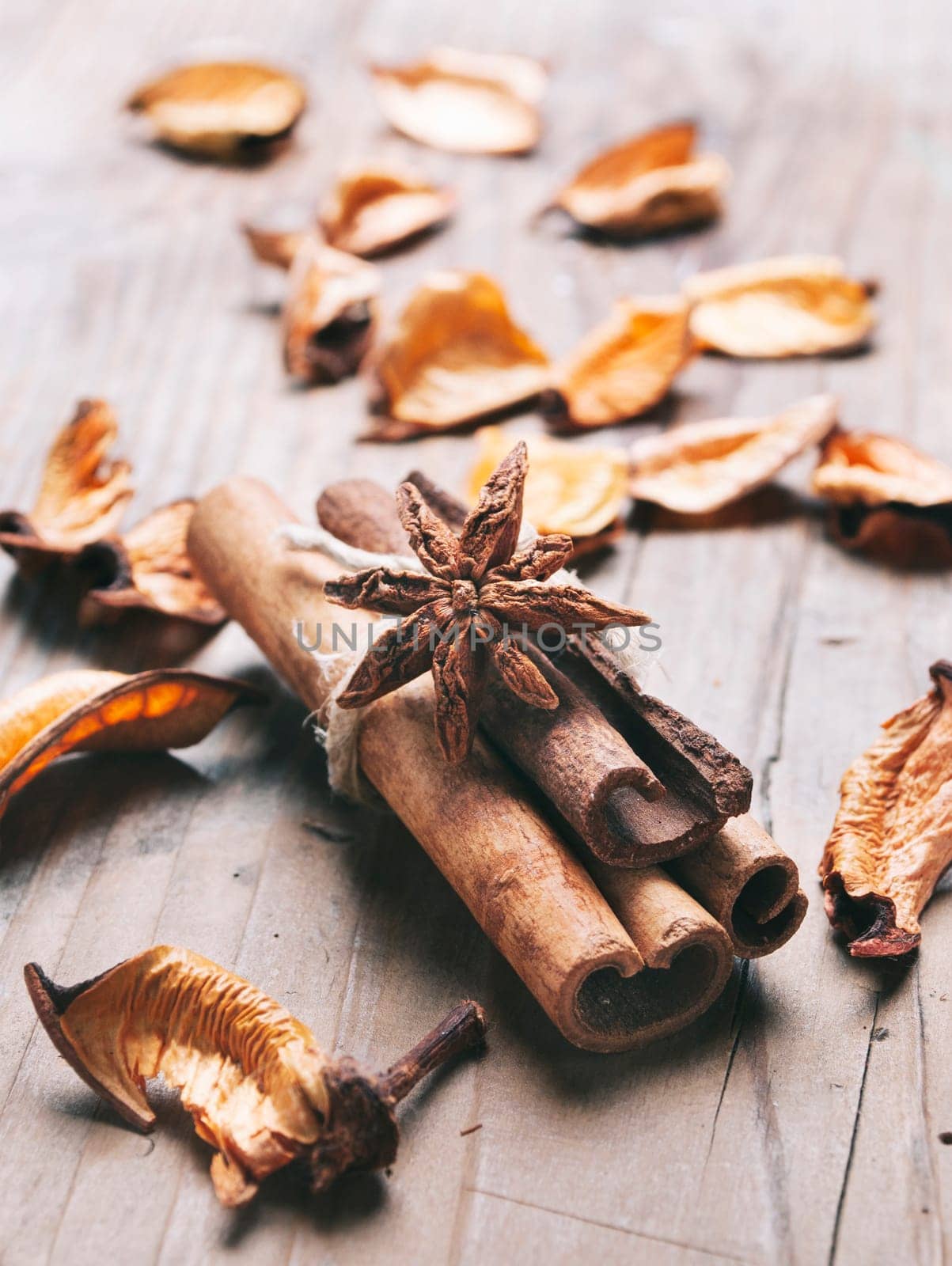 Closeup of cinnamon and anise star flavor with scented dry flower potpourri on vintage wooden table background. Zen relax meditation and aromatherapy treatment with natural herbal medicine.