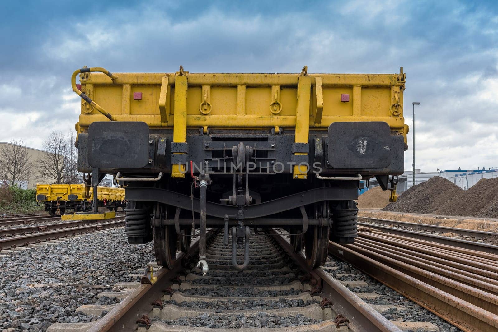 Rear view of a yellow open freight wagon.