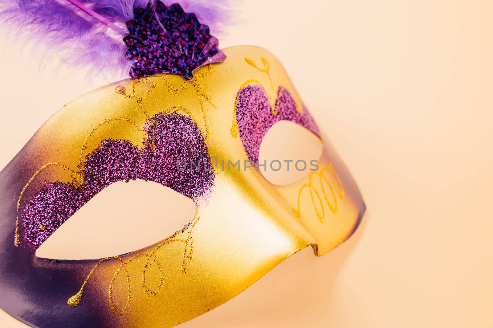 Happy Purim carnival decoration. Jewish Purim and Mardi Gras in Hebrew, Top view venetian ball mask with purple feather on pastel background, holiday background banner design, Masquerade party