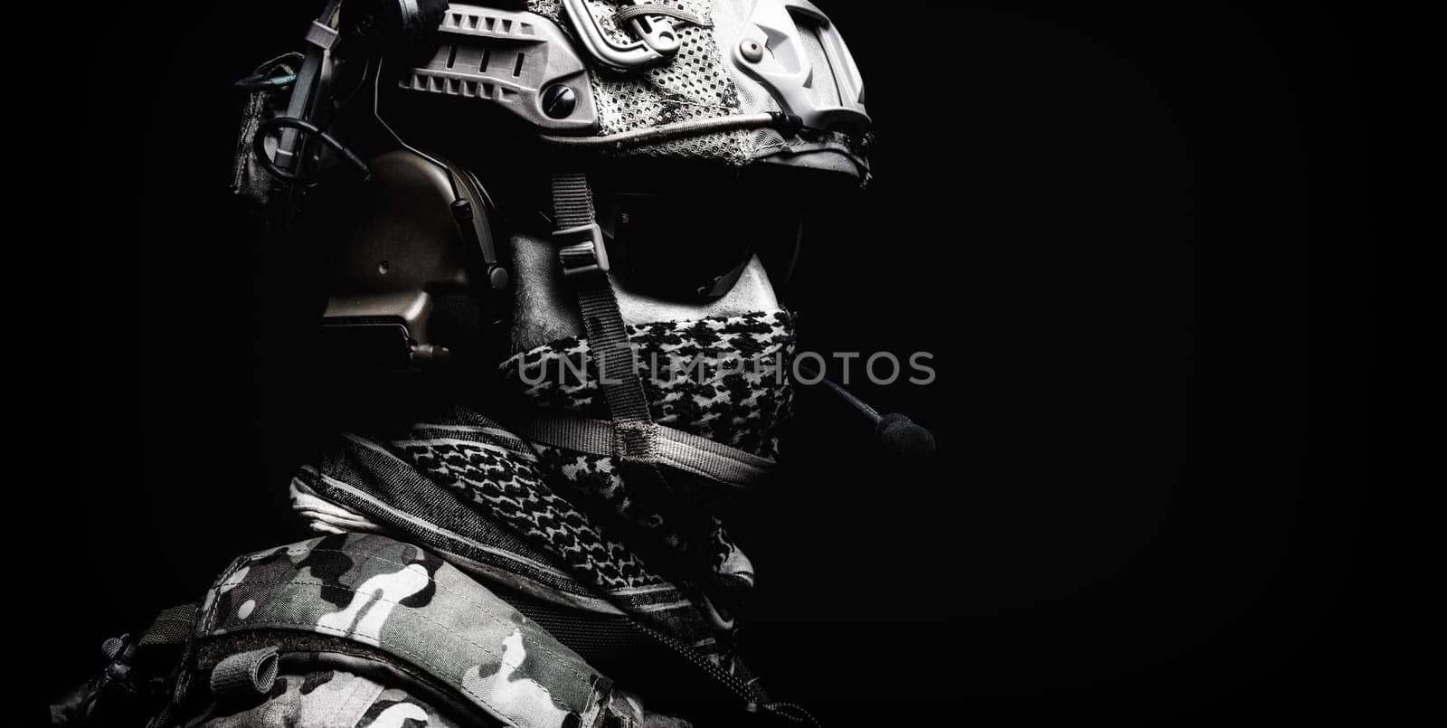 Modern army special forces equipped soldier, anti terrorist squad fighter, elite mercenary in helmet, studio portrait in darkness. Close up, half length