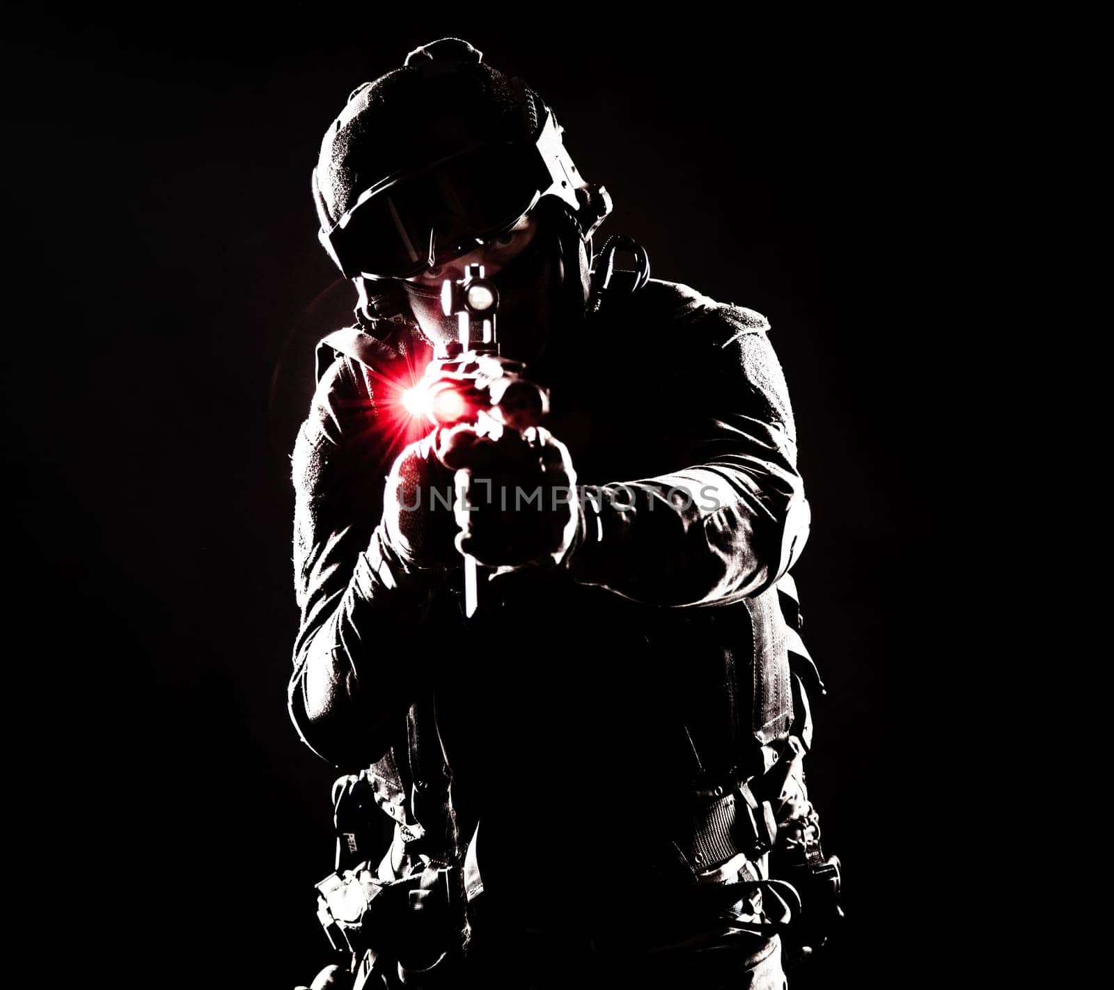 A contour silhouette of a soldier fighting in the darkness. Respect for the sacrifices made by soldiers in defense of their country motherland, symbol of strength and courage. Gun with laser sights, red light
