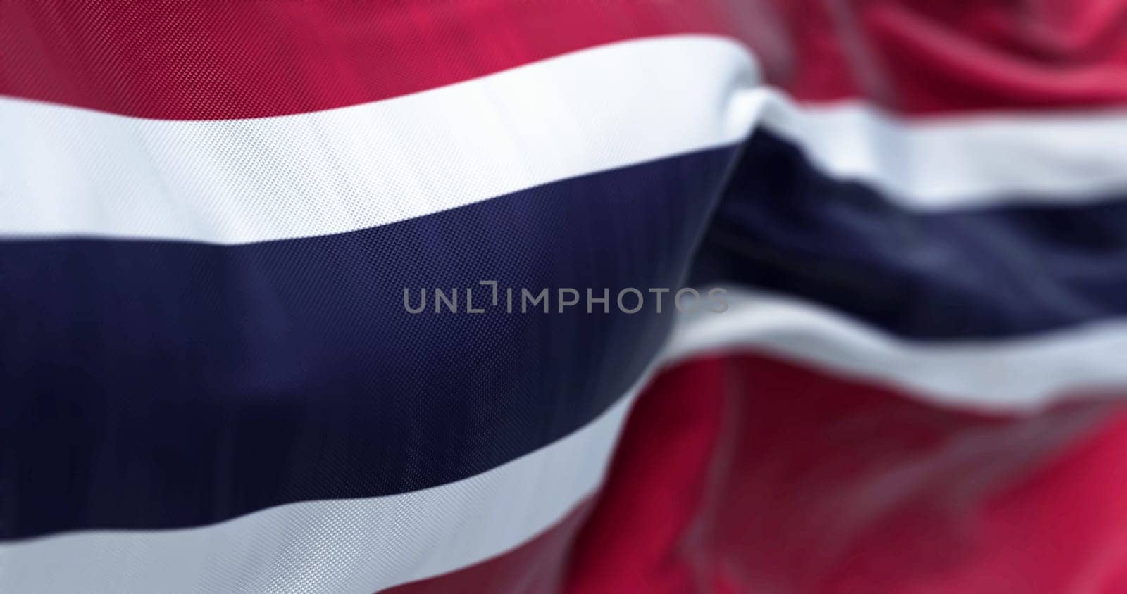 Detail of the Thailand national flag waving in the wind. Five horizontal stripes in red-white-blue-white-red. 3d illustration render. Selective focus. Close-up. Textured fabric background