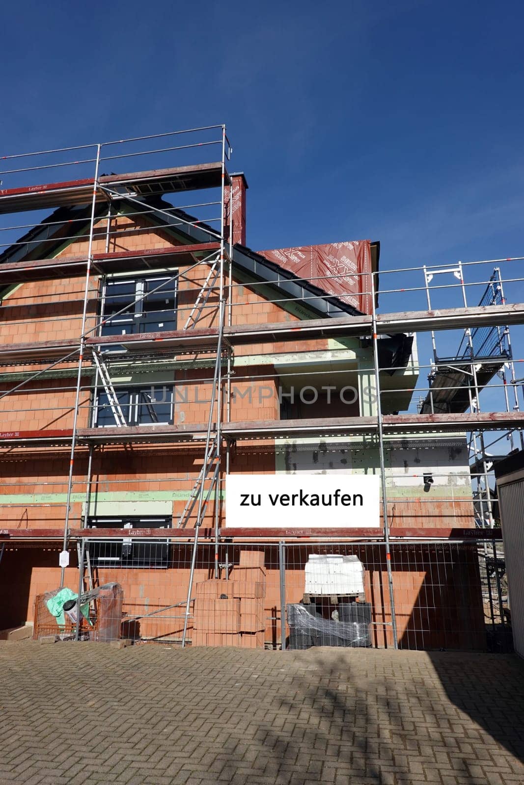 Neubau eines Hauses mit Schild zu verkaufen
