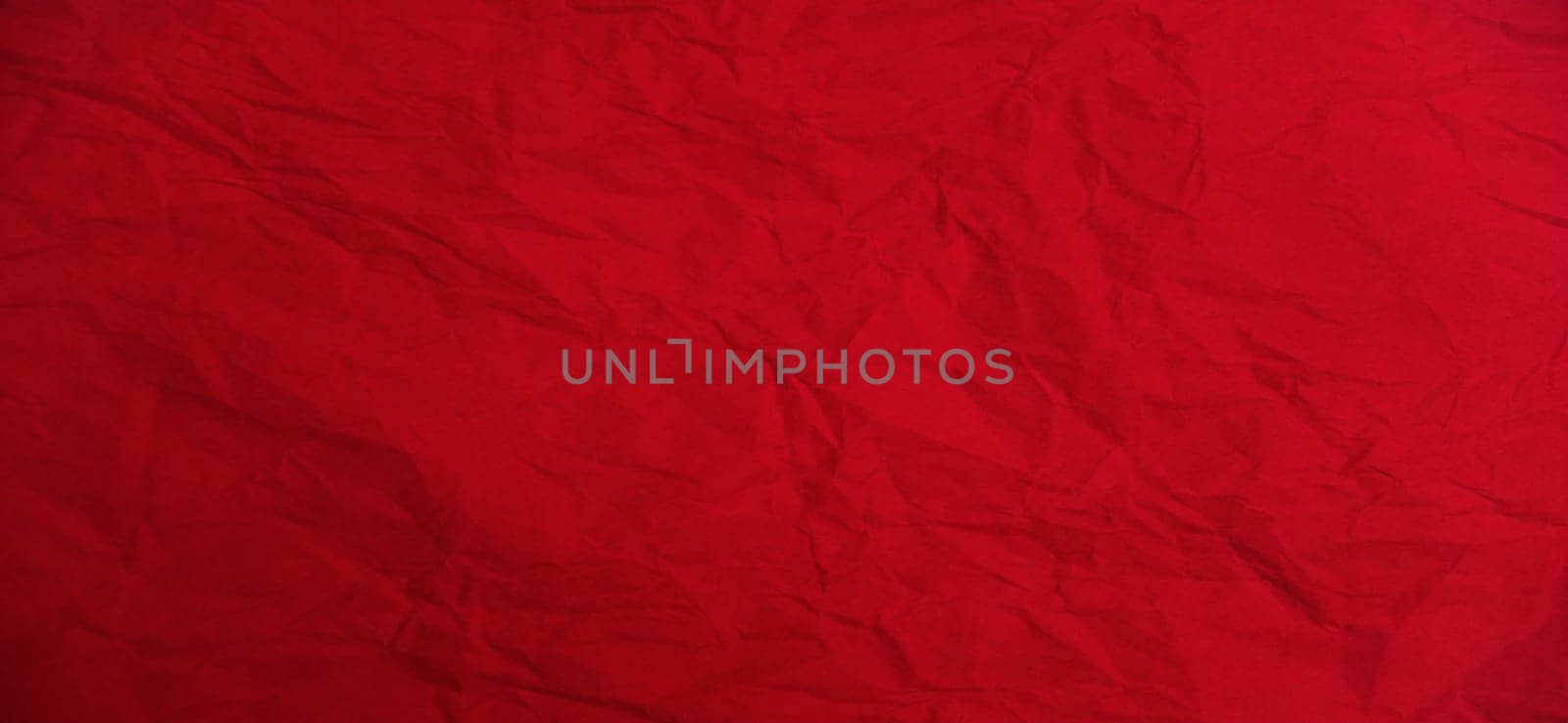 Red beautiful bright background. Scarlet uneven color. Sheet of colored paper. Crumpled paper texture