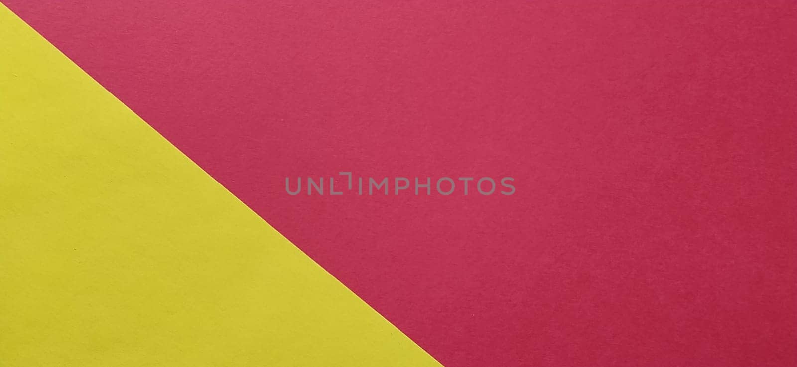 A yellow sheet of paper is laid sideways on a red sheet of paper. Thick paper or thin cardboard. The yellow element is on the left and the red is on the right