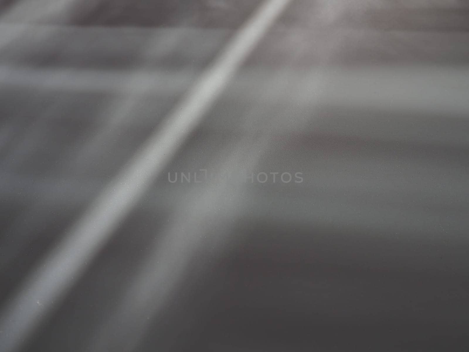 Illumination rays on gray surface. Abstract rays of light and lens flare on a gray background. Vertical, horizontal and diagonal light stripes.