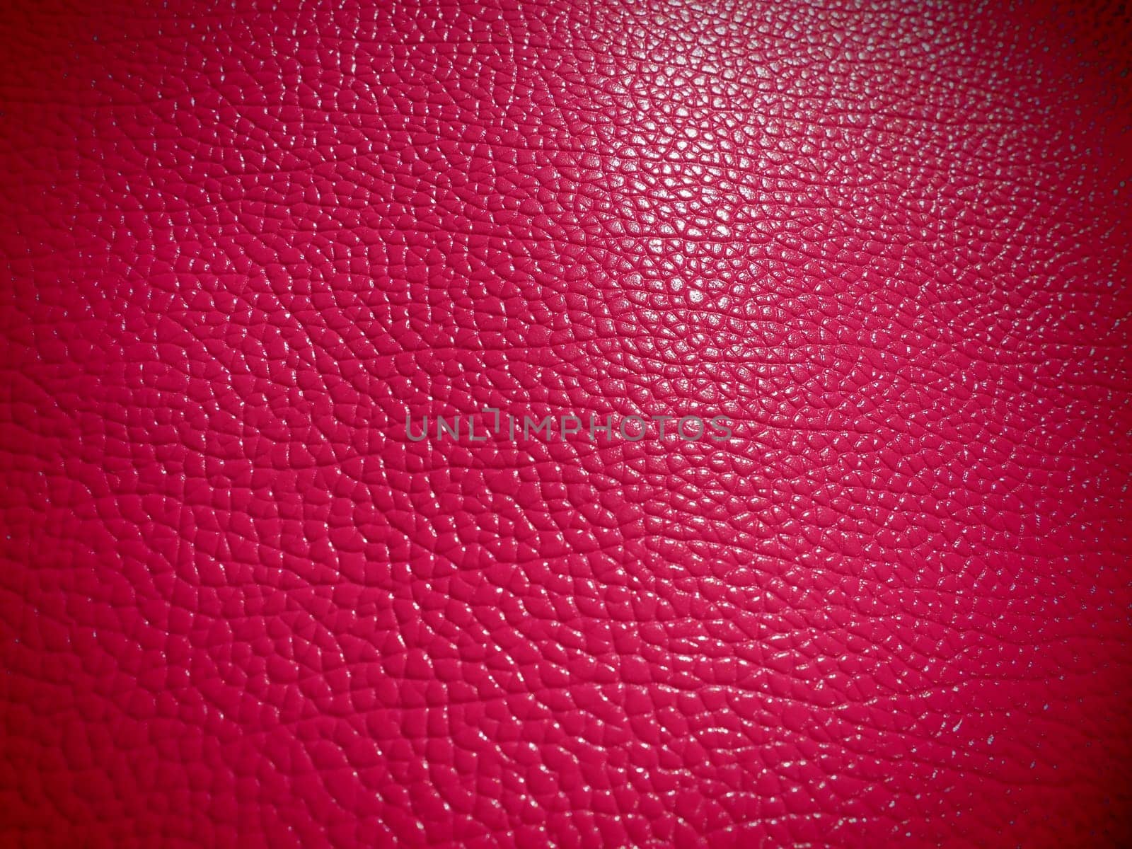 Red or pink leather. Material for fashion accessories, for sewing leather and suede products, furniture upholstery. Natural leather texture. Magenta or fuchsia.