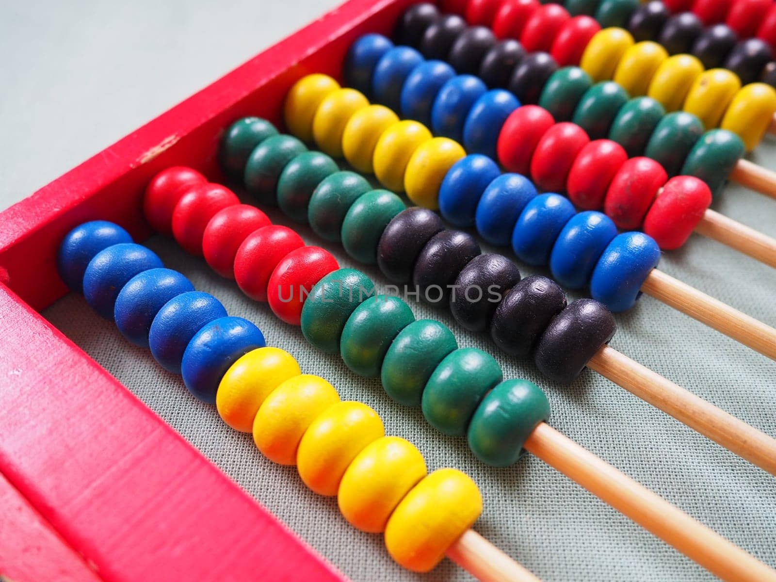 Education concept - abacus with many colorful beads. Red, blue, green, black, yellow details on the abacus. Mathematical exercises. School program.