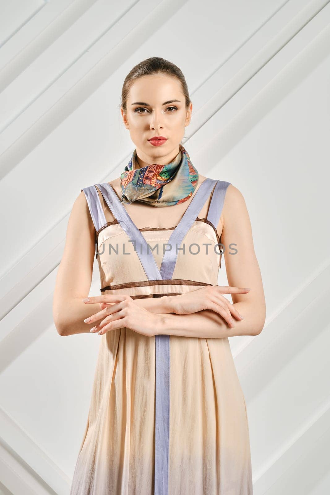 Cute young woman with crossed hands and silk scarf on her neck