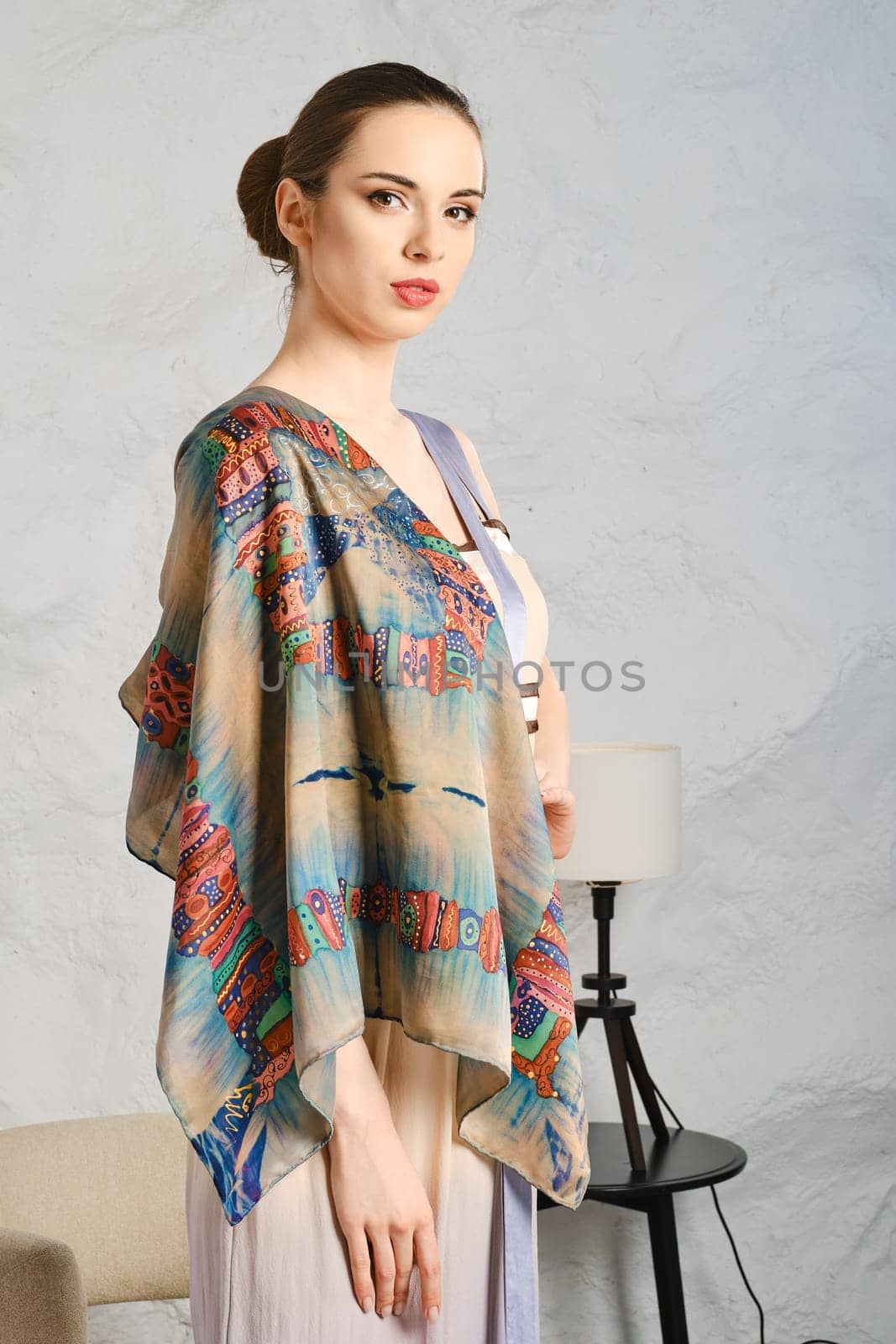 Pretty young woman demonstrating silk shawl thrown on her shoulder