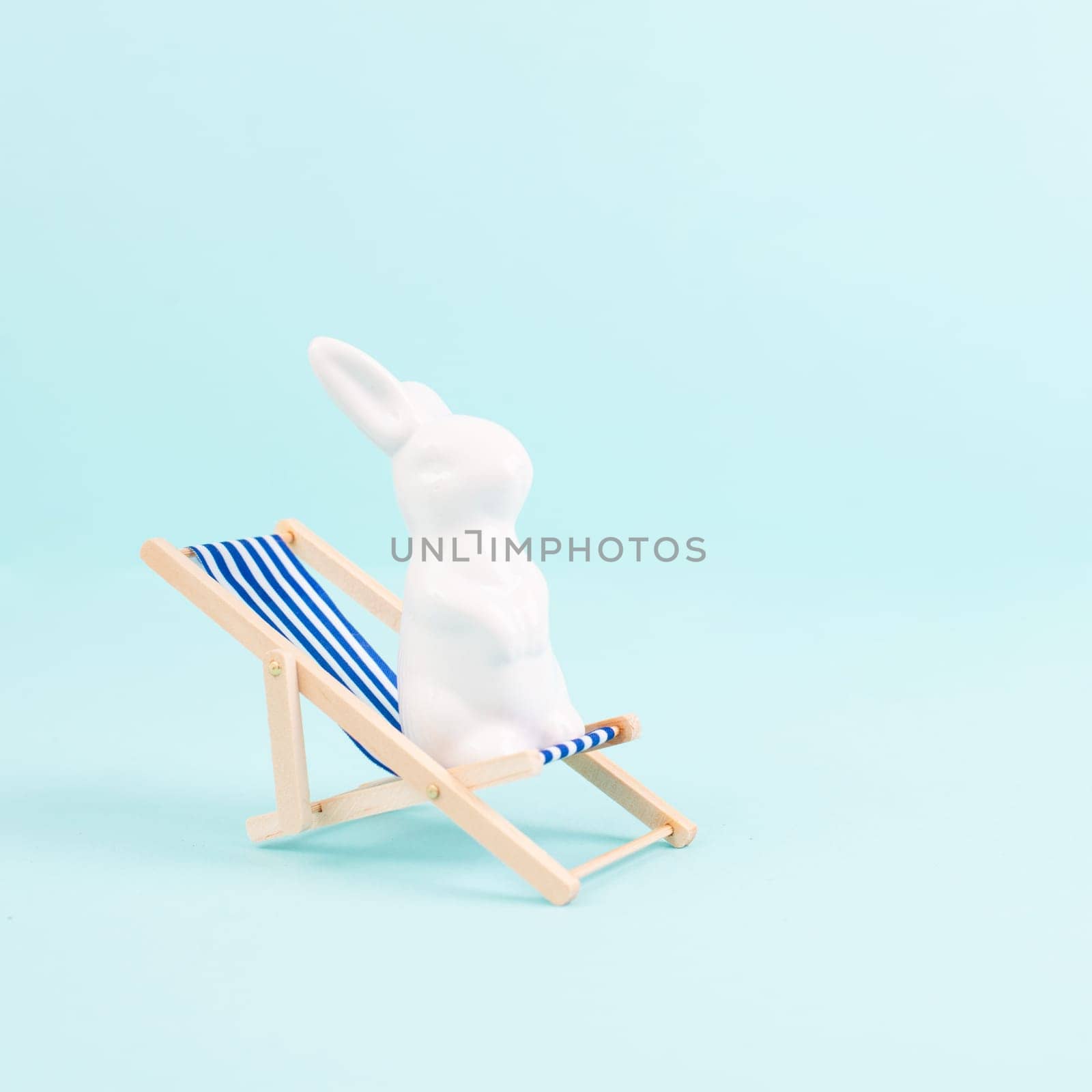 Bunny or rabbit sitting on lounge chair, easter holiday, vacation by the sea