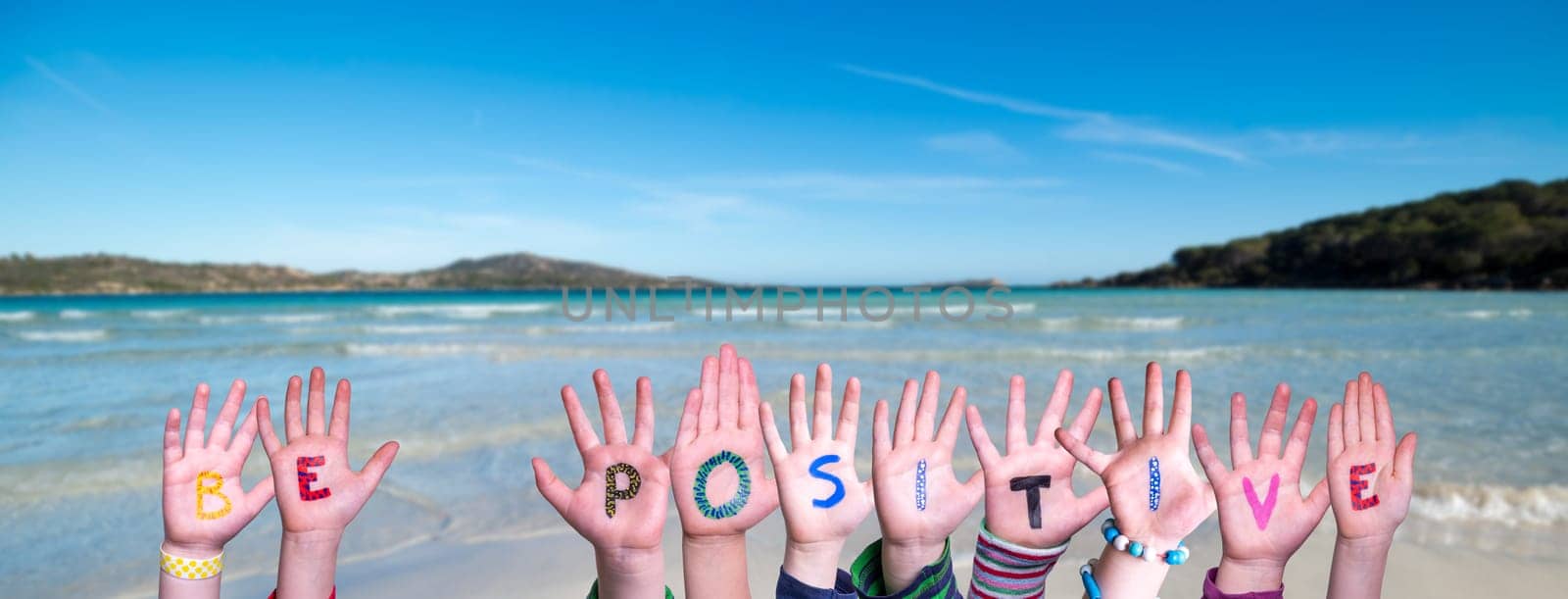 Children Hands Building Colorful English Word Be Positive. Summer Ocean, Sea And Beach As Background