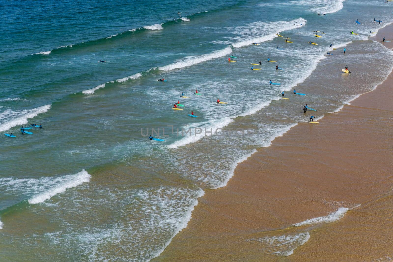 Sagres, Portugal - August 25, 2022: View of surfers on sandy beach near Sagres village in Algarve, Portugal