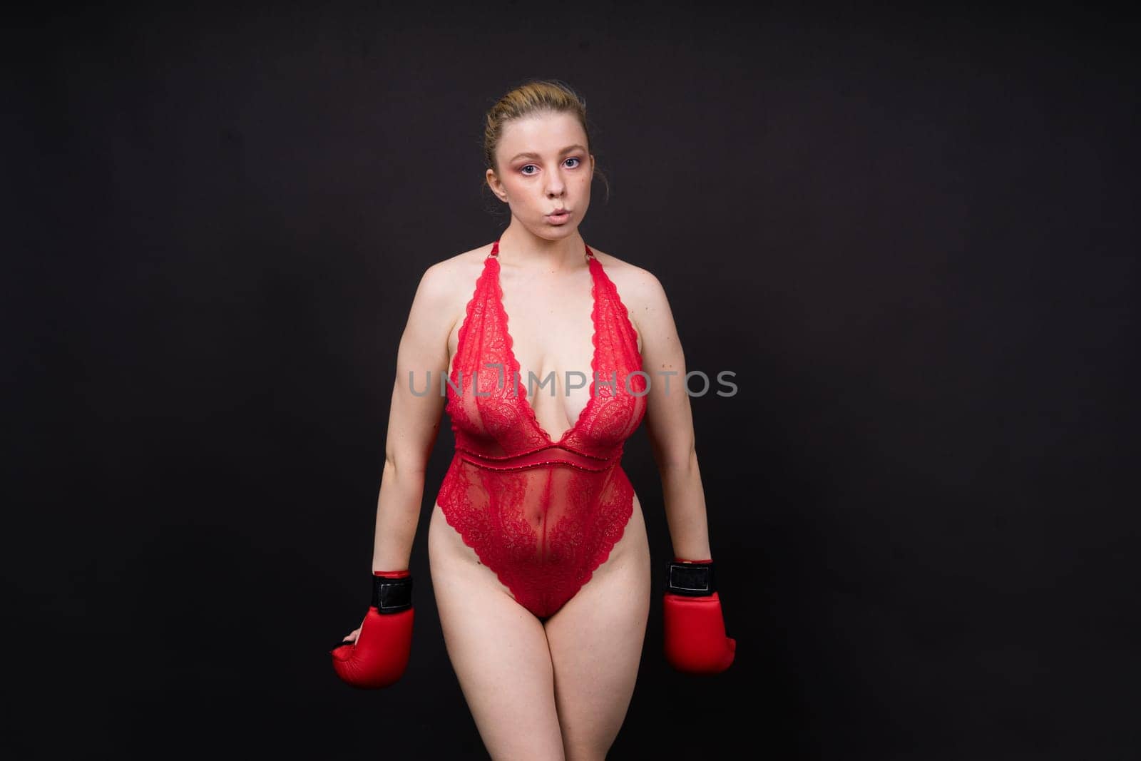 Boxer, seductive confident female boxer with gloves studio, sporty woman posing looking to camera.