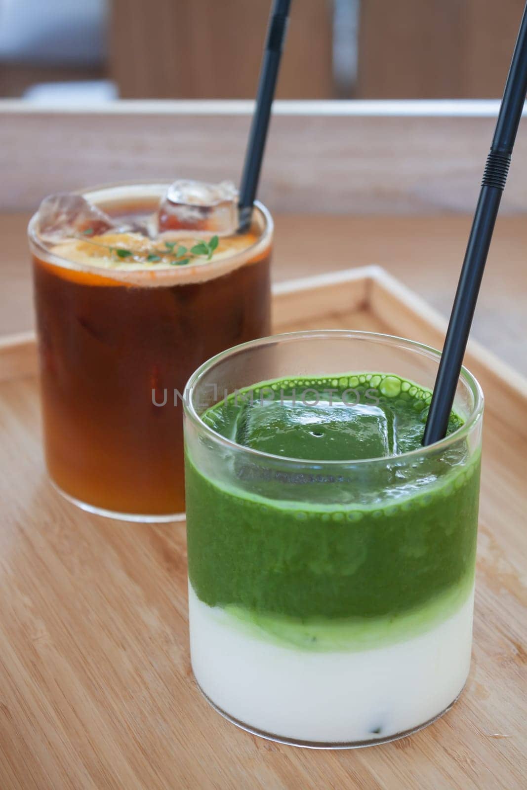 Iced americano with orange and iced matcha green tea in coffee shop, stock photo