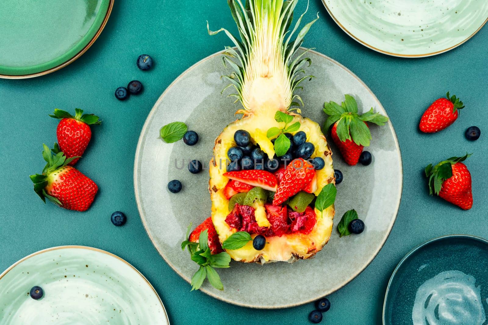 Healthy fresh fruit salad of strawberries, kiwi, berries and orange in half a pineapple.