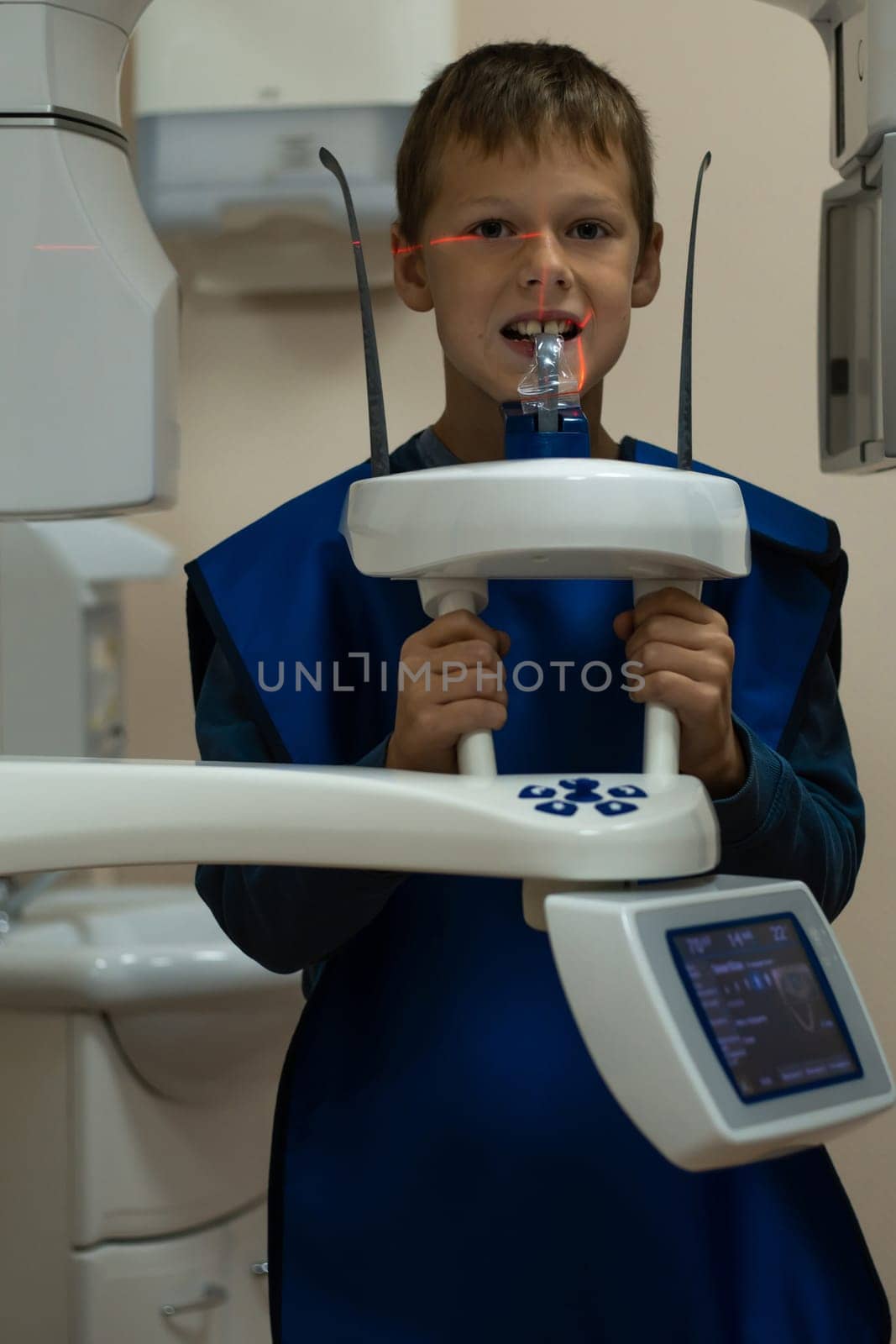 Jaw computed tomography, check up teeth in dental clinic. Little boy with open mouth on x-ray diagnostics. Circular snapshot of jaw on modern medical equipment. CT scanning, stomatology and radiology.