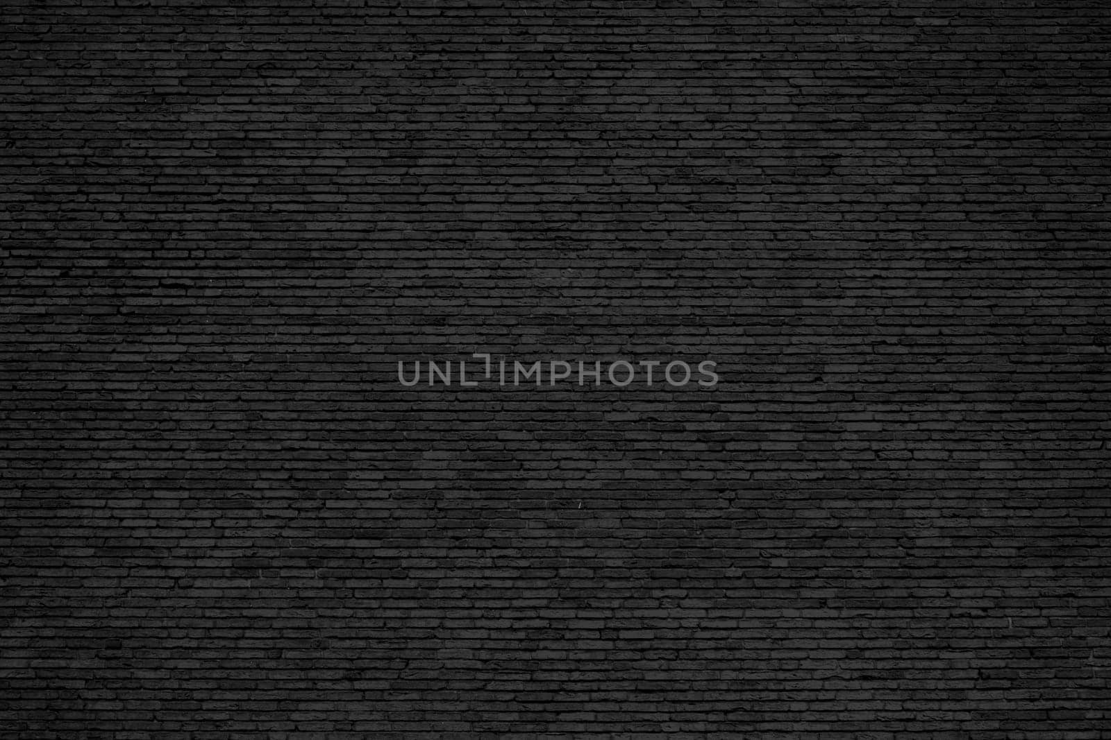 Black brick wall background with weathered stones