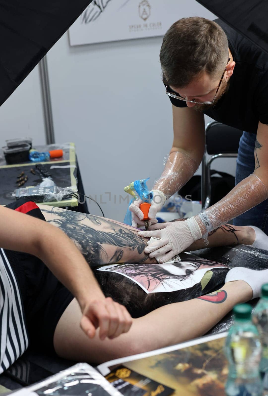 Krakow, Poland -  June 12, 2022: Unidentified  participant at 15th Tattoofest Convention in Cracow. One of the most prestigious tattoo festivals. Tattoo artist at work.