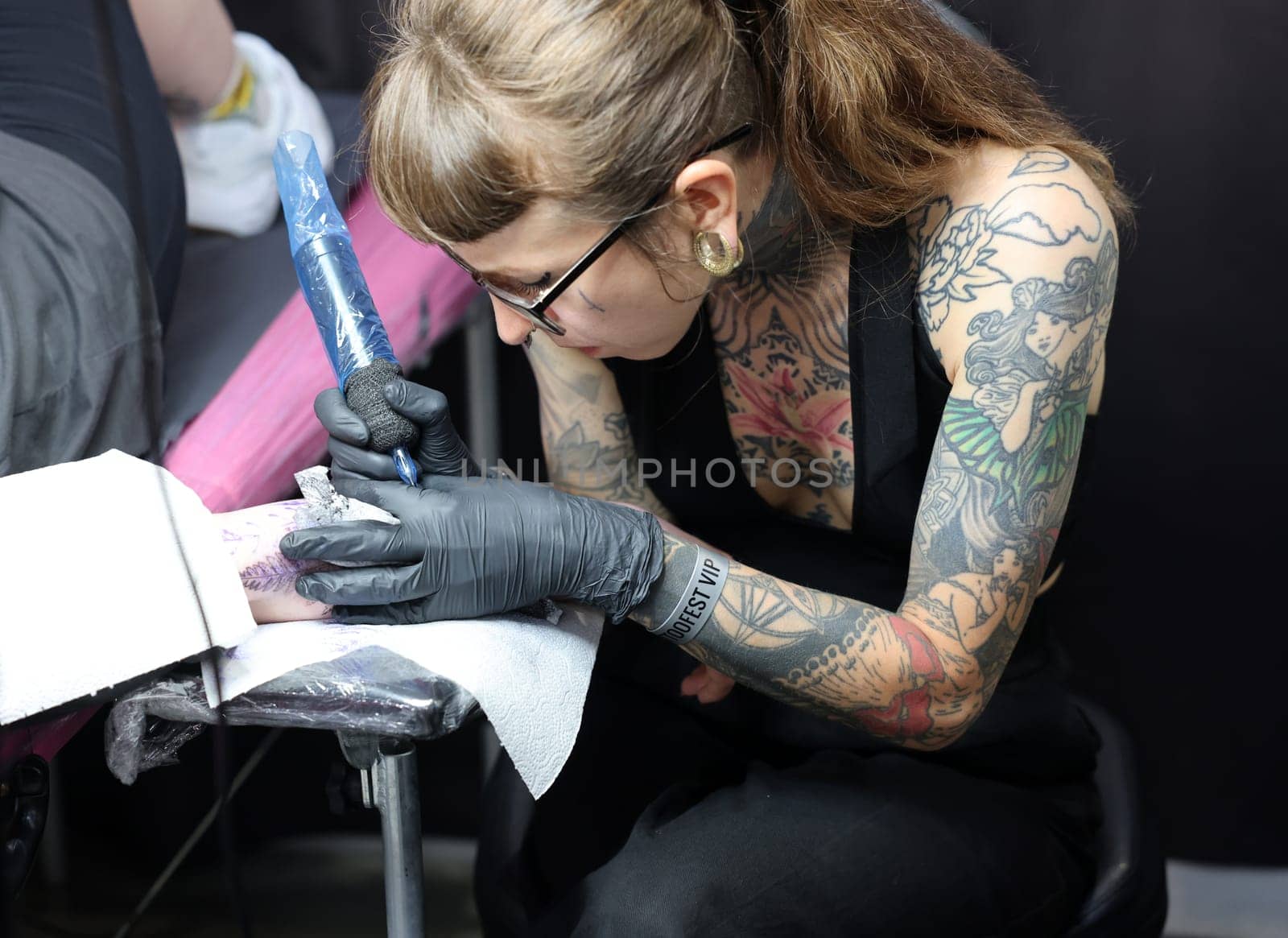 Krakow, Poland -  June 12, 2022: Unidentified  participant at 15th Tattoofest Convention in Cracow. Tattoo artist at work.