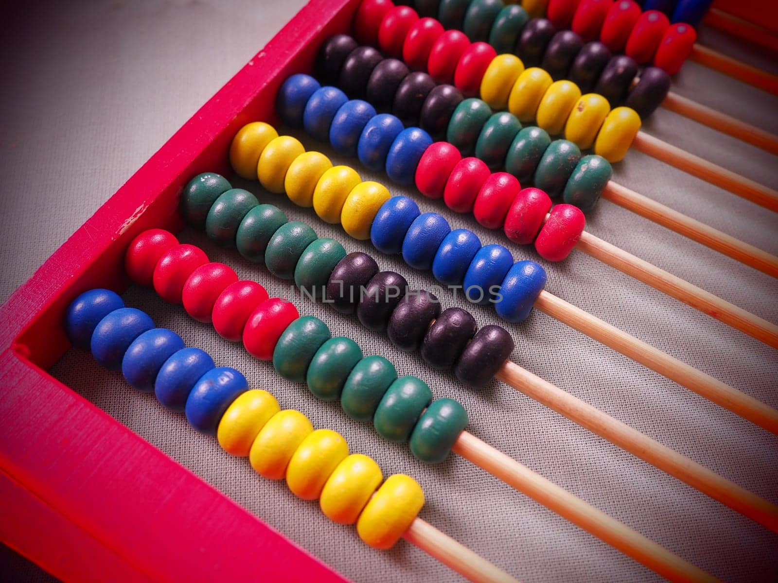 Education concept - abacus with many colorful beads. Red, blue, green, black, yellow details on the abacus. Mathematical exercises. School program.
