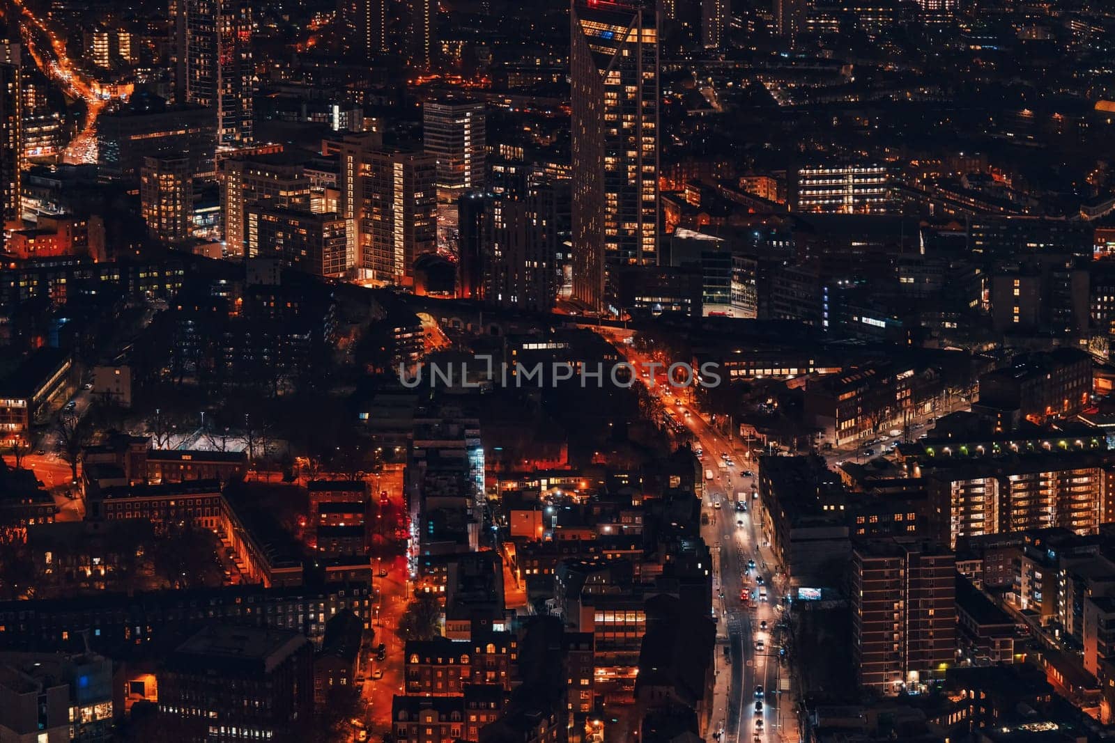 Night aerial view of south west London, orange yellow street lights glowing, small cars visible on main road.