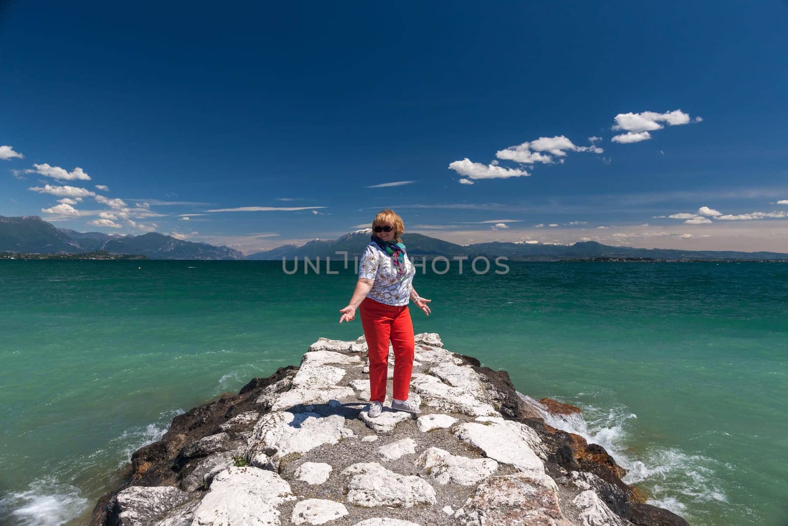 Lake Garda Italy. happy woman against the backdrop of emerald water