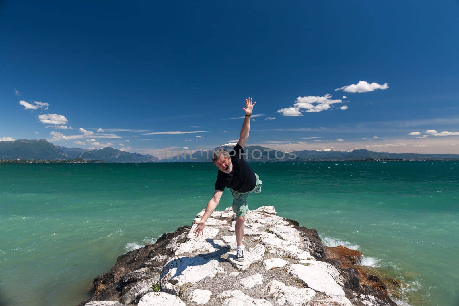 Lake Garda Italy. happy man against the backdrop of emerald water