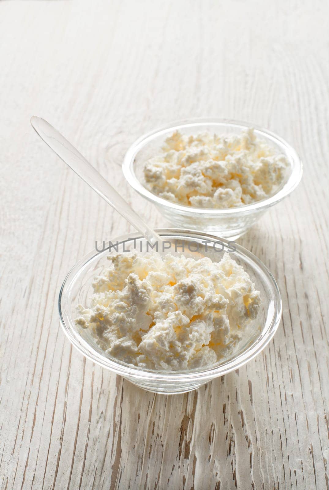 Fresh cottage cheese in a bowl on a wooden background