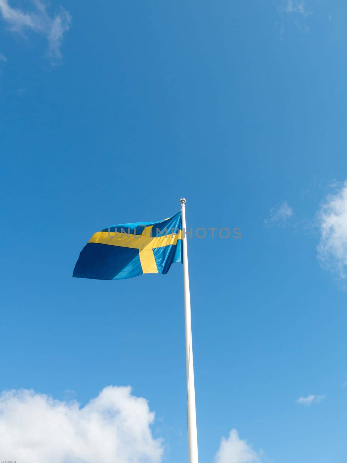 Swedish flag blowing in the wind on the blue sky