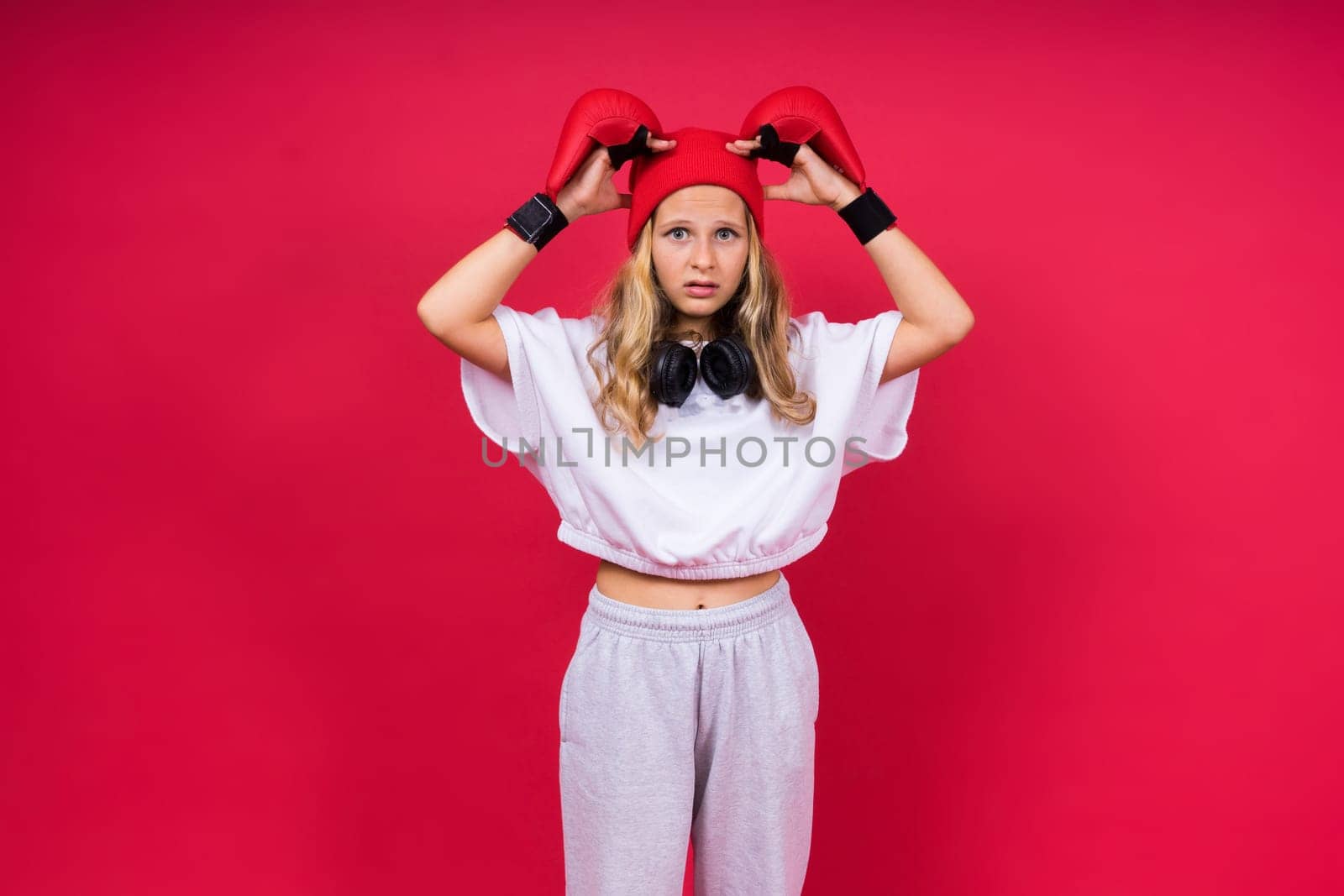 Little girl wearing red boxing gloves, studio shot, sport conception