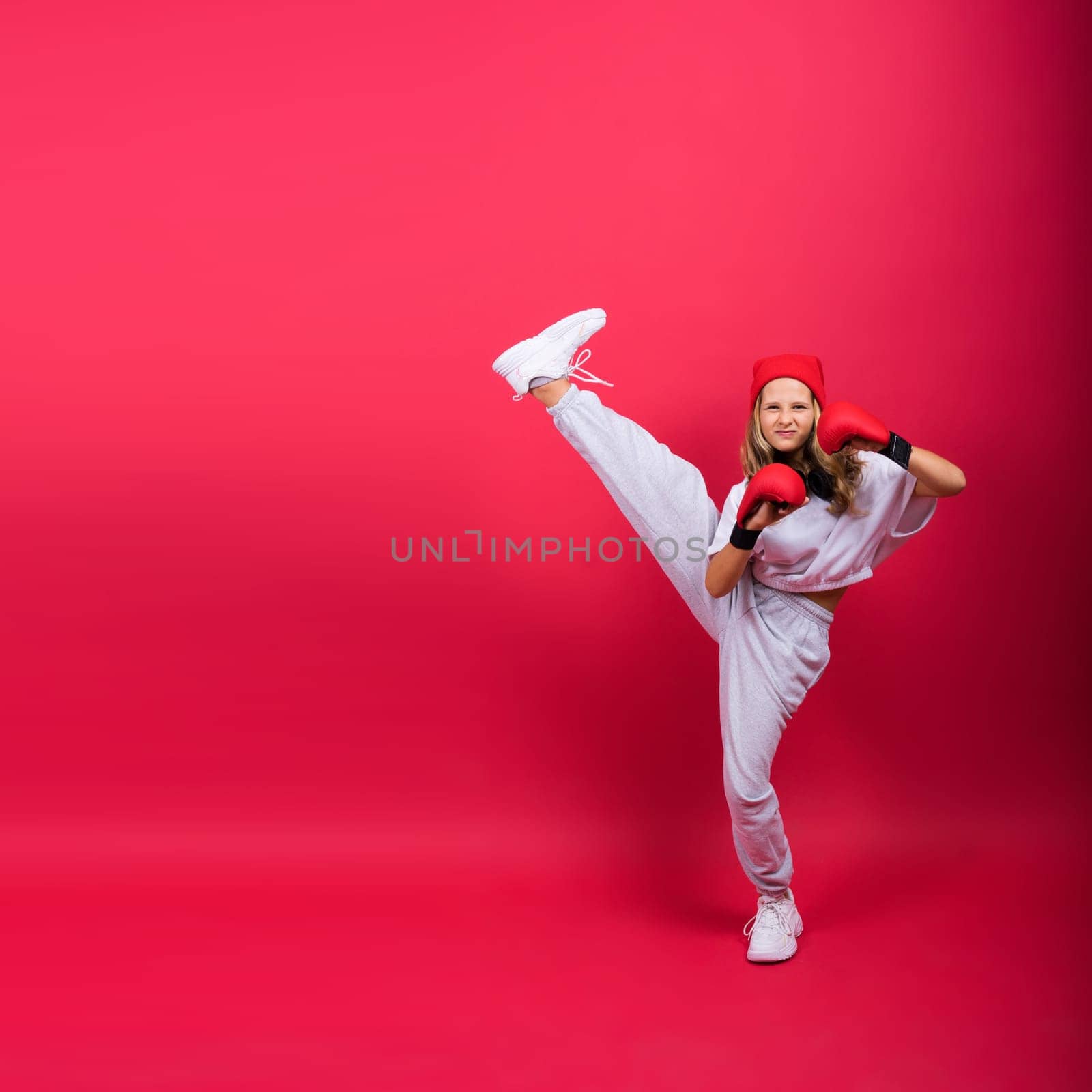 Little girl wearing red boxing gloves, studio shot, sport conception