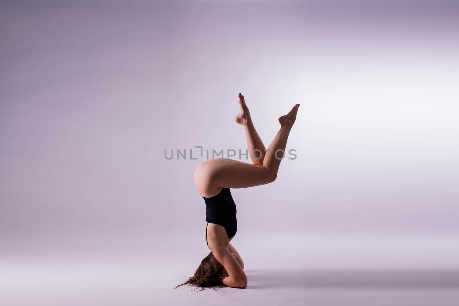 Image of a young plump female doing acrobatic stunt, studio shot