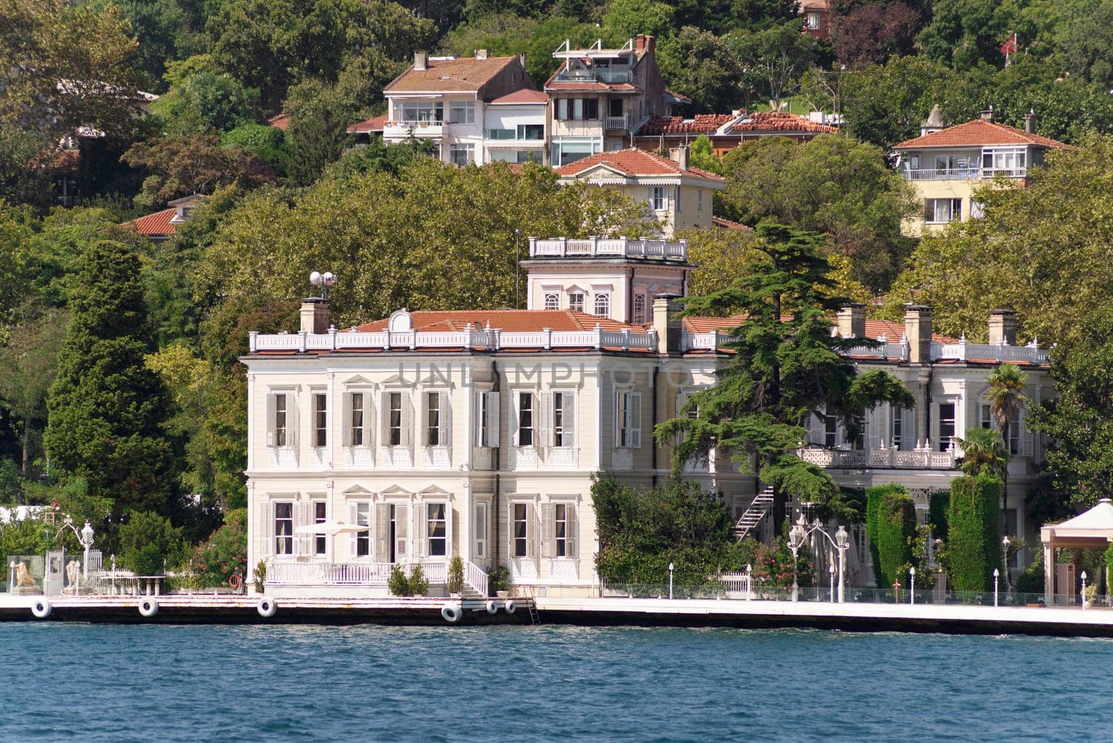 View from the sea of the European side of Bosphorus strait, Istanbul, Turkey, with traditional houses, and green mountains with dense green trees, in a summer day