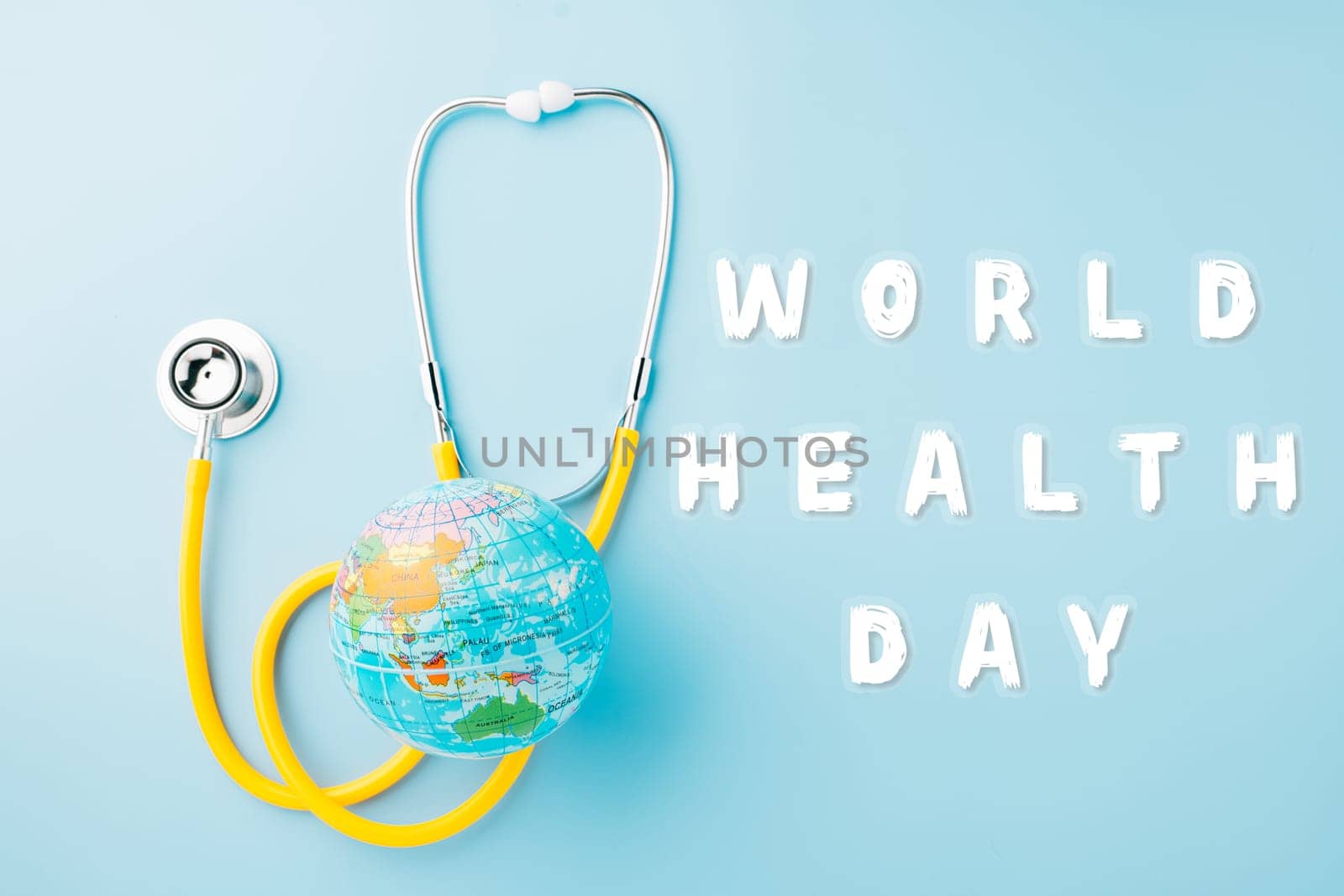 World Health Day. Yellow doctor stethoscope and world globe isolated on blue background, Save world day, Green Earth, Healthcare and medical concept