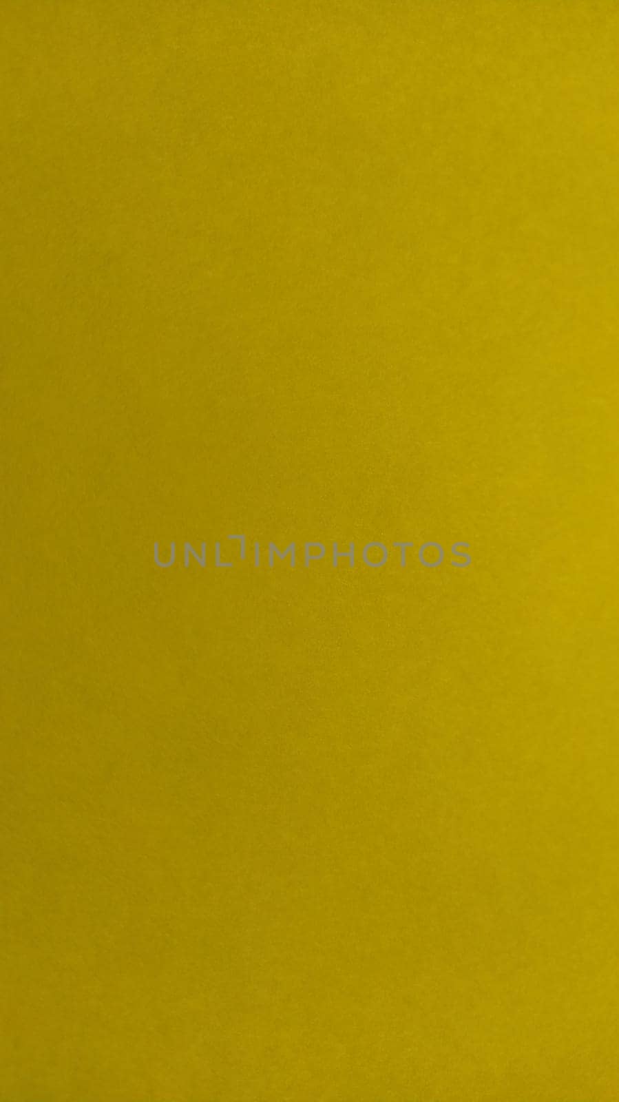 The paper or fabric is bright yellow. Close-up. Lightly folded sheet. Light gradient and accentuated rough surface texture. Background or product sample. Sunny cheerful yellow. Vertical