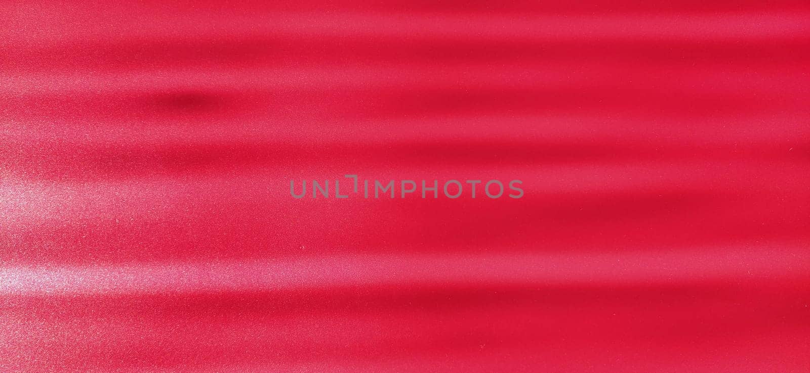blurred striped sparkling pink background. Oblique horizontal beams of light on shiny fuchsia plastic surface.