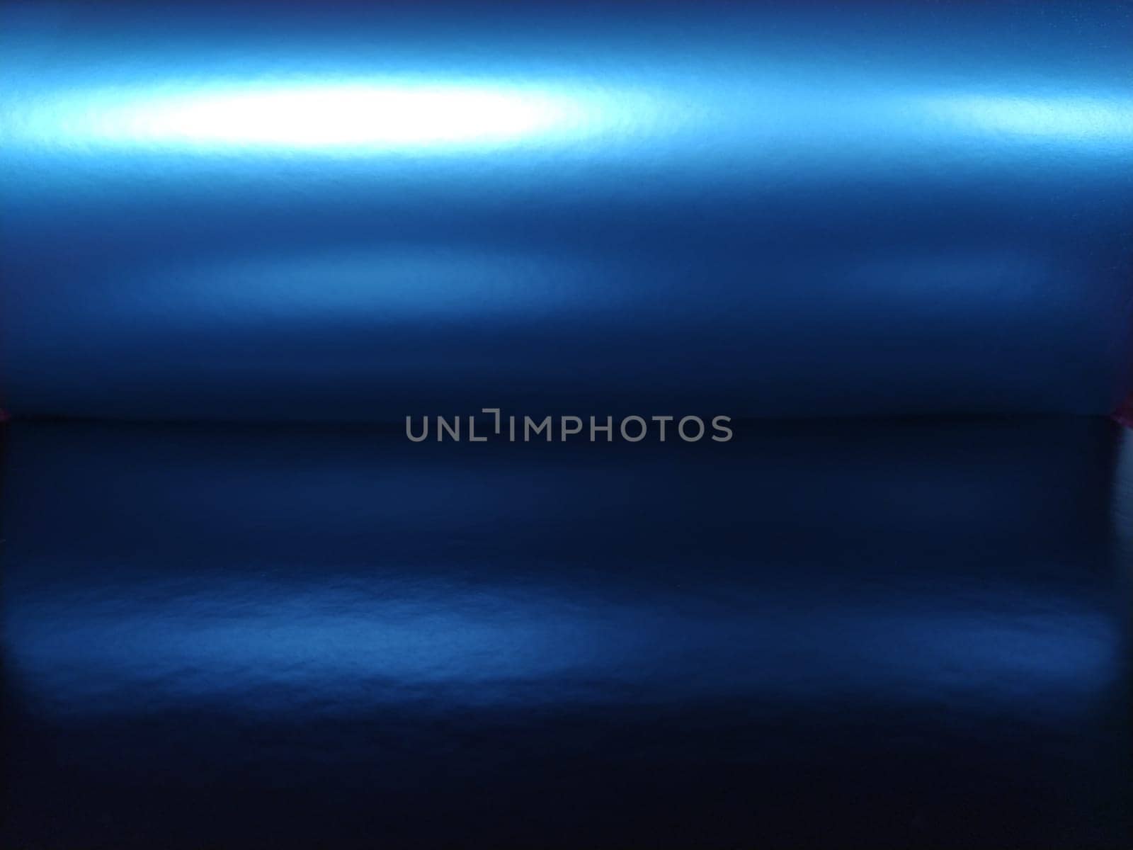 Gradient on a blue background. Horizontally folded shiny paper or foil with overflow and highlights. Mysterious radiance. Northern Lights. Luxurious fabric. Metallic cold shine. Lighted up.