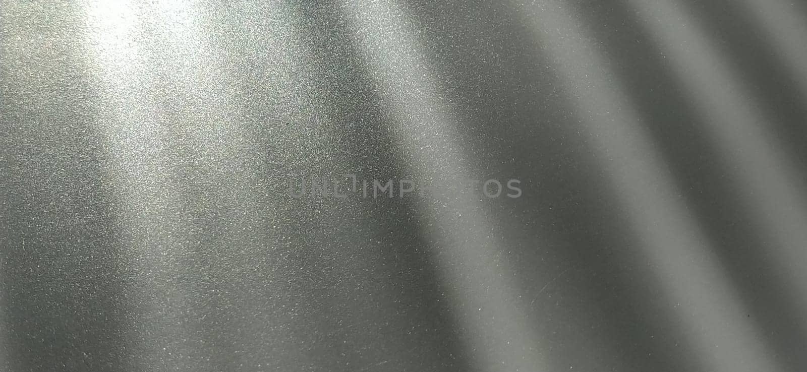 Gray striped background with oblique light effect. Play of light and shadow. Light rays. Gray and silver shades with white dots and shining stars. Diagonal lines from left to right.