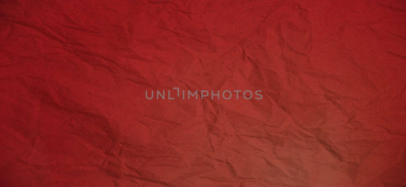 Crumpled red paper. Abstract background. dark red to lighter shade.