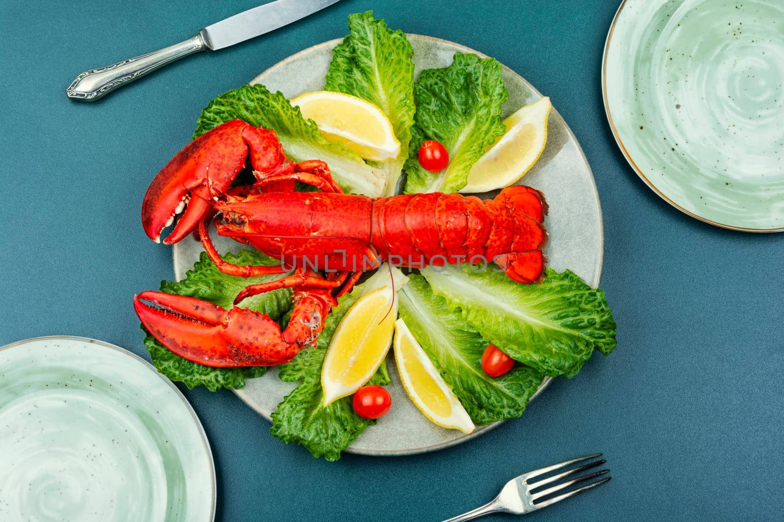 Boiled lobster with lettuce and lemon on a plate. Seafood, copy space