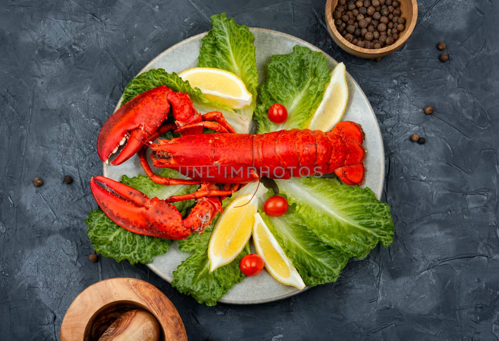 Boiled lobster with lettuce and lemon on a plate. Seafood, copy space